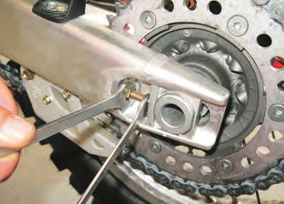 Make sure that the chain features a slack (A) measuring approximately 12 mm, as shown in the nameplate (1) on swingarm.