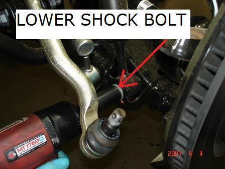 9. Remove the lower shock nut and bolt on both sides.