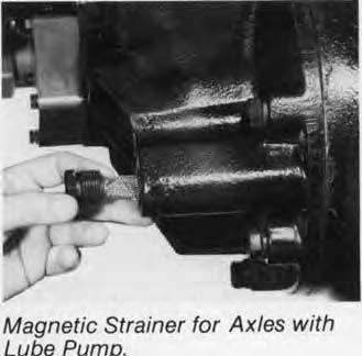 Axles with Lube Pump: Remove the magnetic strainer from the power divider cover and inspect for wear material in the same manner as the drain plug.