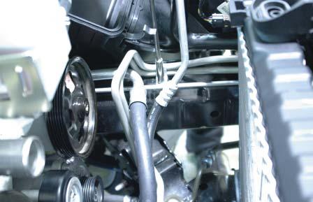 Remove the mounting bolts from the transmission cooler hard-line bracket at the
