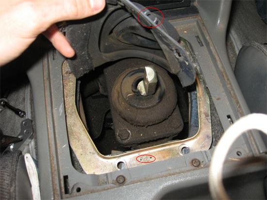 5. Use the 8 mm socket wrench to remove the two visible bolts retaining the metal ring around the second shifter boot.