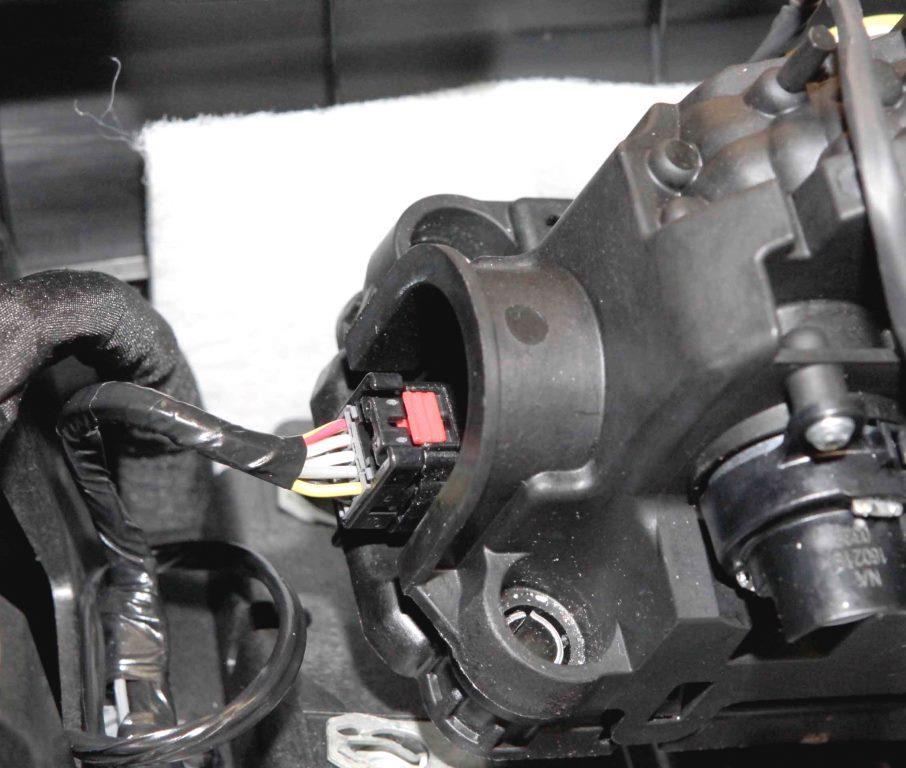 Disconnect the gear selector electrical connector by depressing and sliding back the red tab on top of the gear selector electrical connector prior to