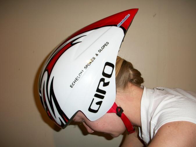 Riding with their head down, at a negative pitch angle, negates the benefit of a traditional aerodynamic helmet by increasing frontal area and altering the drag coefficient.