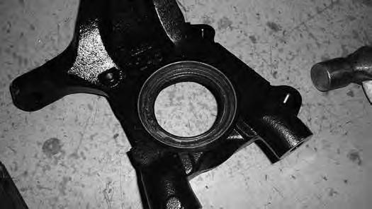 Remove the factory unit bearing and dust shield from the OE steering knuckle.