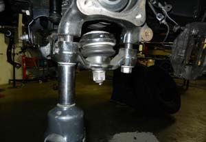 Loosen the lower control arm cams and let swing out of the way. Remove the strut from the frame.