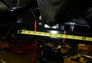 Mark a vertical line from the center of the driver rear control arm pocket out 2 3/4 onto the rear cross member.