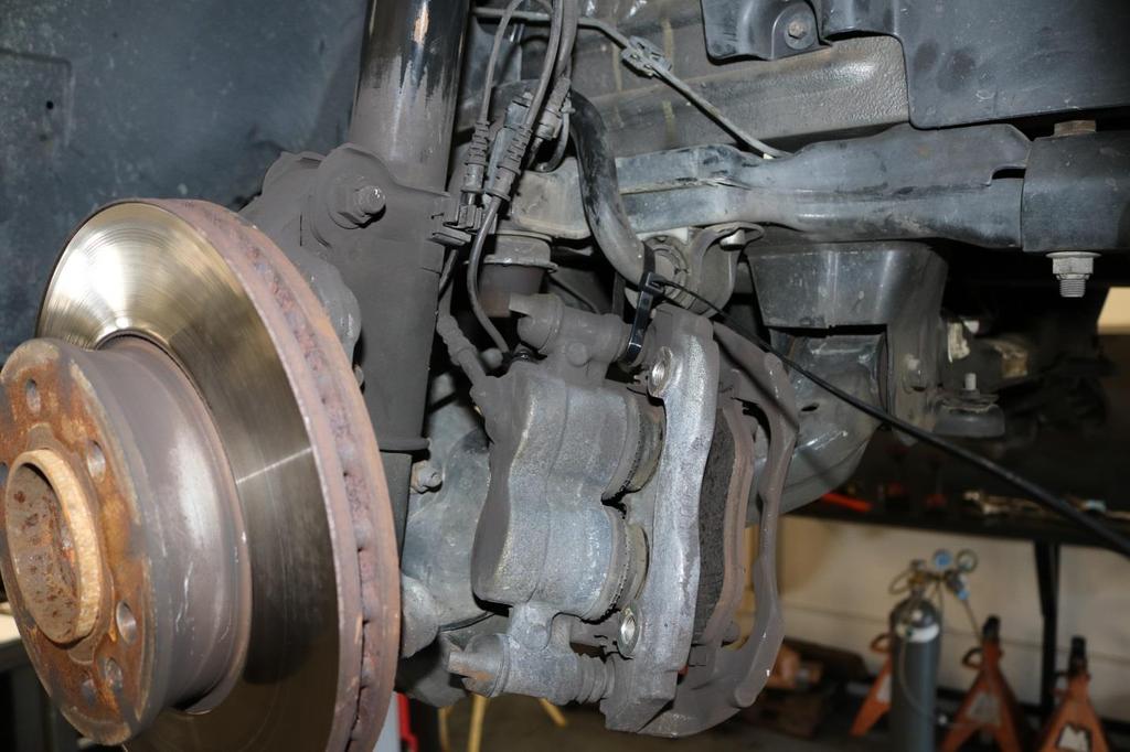 14) Remove the brake caliper from the rotor and secure up
