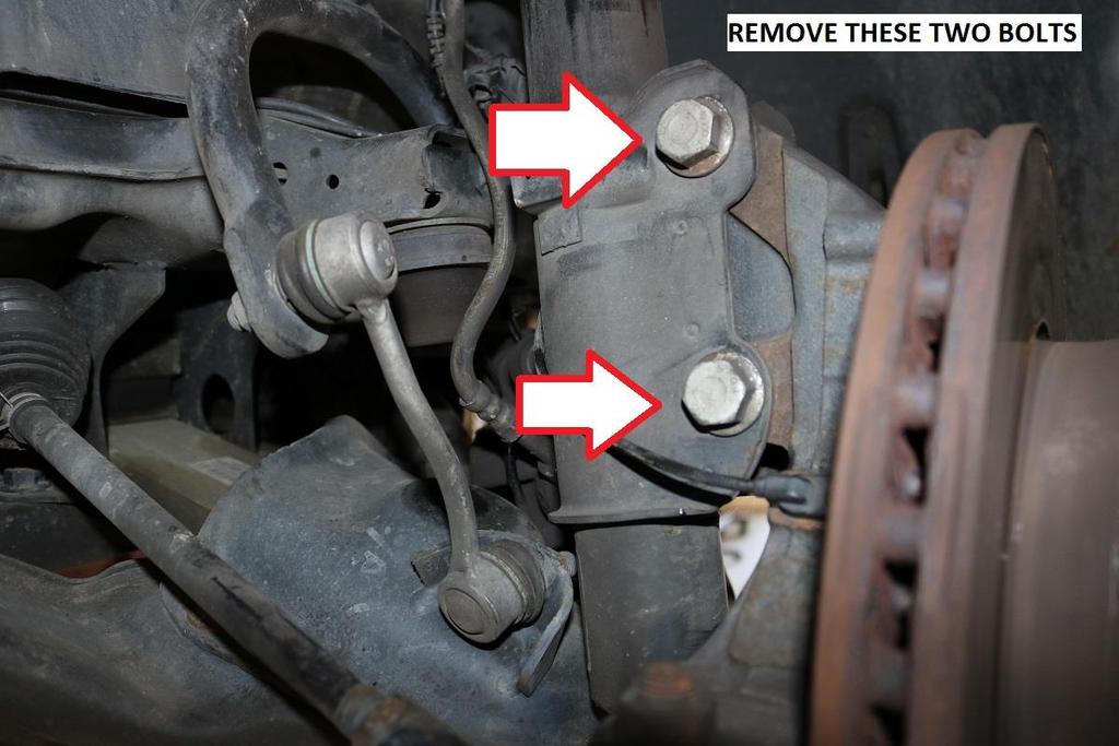 15) Raise the lower control arm about 3/8 (10mm) to remove tension from the strut.