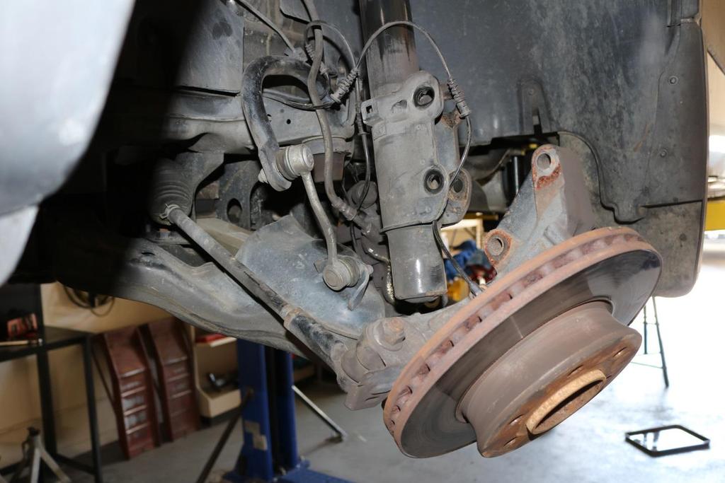 16) With the strut disconnected from the steering knuckle, allow the lower control arm to hang