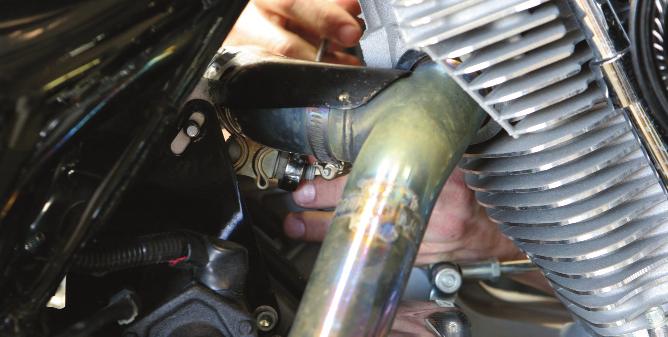 Loosen the exhaust clamp at the starter mount.