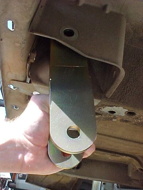 With the axle supported by the floor jack, carefully remove the upper and lower spring shackle