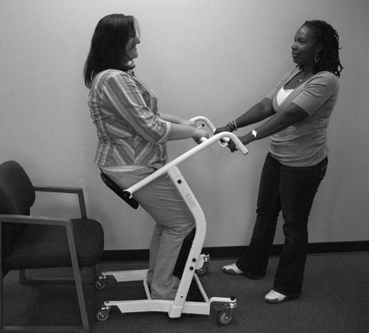 Have the patient lower herself down onto the seat while keeping her knees and shins in the kneepads, and while continuing to hold the cross bar with both hands, as shown at right. 7.