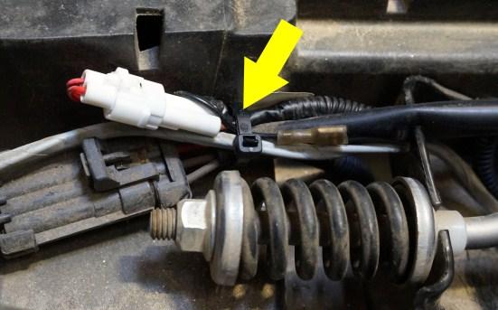 Using cable ties, secure the connection and ground to the existing group of wires. Also secure the brake switch wire to the gray sensor wire.