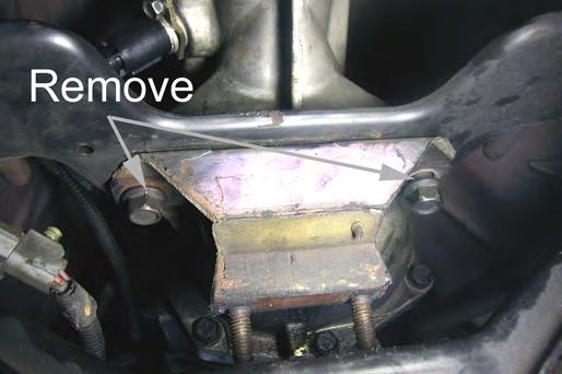 Lower and rotate the transmission crossmember to provide access to the two bolts holding the transmission mount to the transmission.