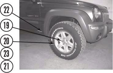Using a hydraulic jack, slowly lift front of vehicle so that front tires (21) are three to five inches off of ground.