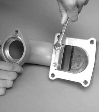 Using a 10 mm wrench, remove the flap valve assembly from the