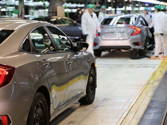Honda Civics are checked by workers as they come down the assembly line at Honda Manufacturing of Indiana's Greensburg facility.