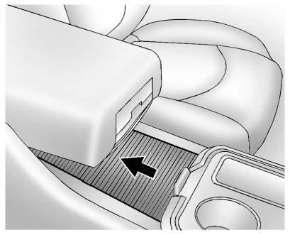 To open the armrest storage area, press the button located on the front of the