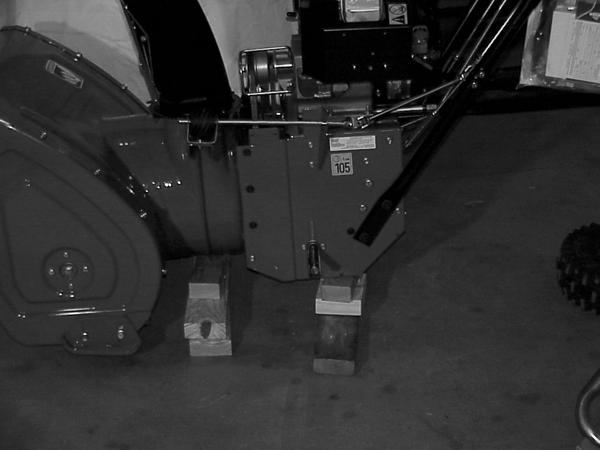 Place a block of wood under BOTH the auger and traction assembly to support them when the connecting cap screws are removed.