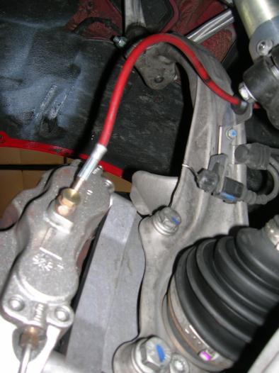10 Orient brake line on caliper so that there is no binding or stretching of the line when the upright assembly is turned from full lock left to right (checked at ride height position).