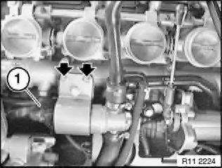 Detach bracket for idle-speed control valve from return line and lay with hoses to one side.