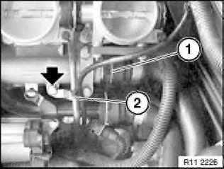 Unlock water hose (1) and detach from return line.