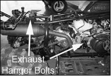 Remove the two mounting bolts that attach the exhaust pipe to the exhaust port on the under side of the engine cylinder.