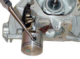 The cylinder is attached t the crankcase with fur screws, which are accessed frm the tp f the cylinder.