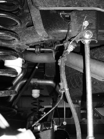 FIGURE 2 9. Remove rear sway bar links, retain hardware. 10. Lower the rear axle and remove the coils, retain the rubber isolators. 11.