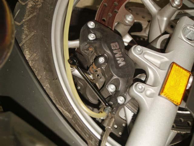 At the caliper, release the pressure by turning the wrench counterclockwise about 1/4 turn.