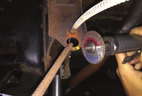 11. Using a cutoff wheel, cut the factory e-brake cable mount and bend. See Photo 7. 12.