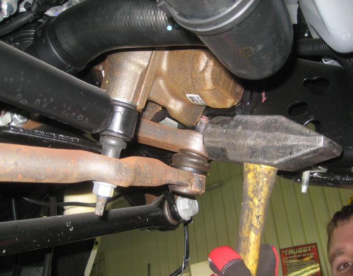 Using a proper tie rod removal tool and/or a hammer, hit