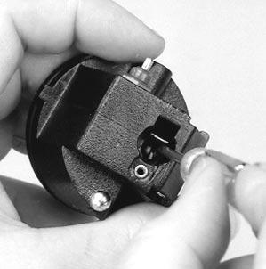 Unthread and remove the screw (P/N 633694), charging contact (P/N 89948), nut (P/N 50249), lockwasher (P/N 56874), and the contact wire assembly (P/N 484821) (the white wire).