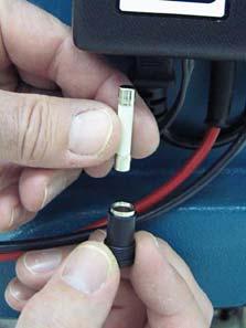 Using a screw driver, remove the fuse holder located at the bottom of the charger (Figure 6). FIG.
