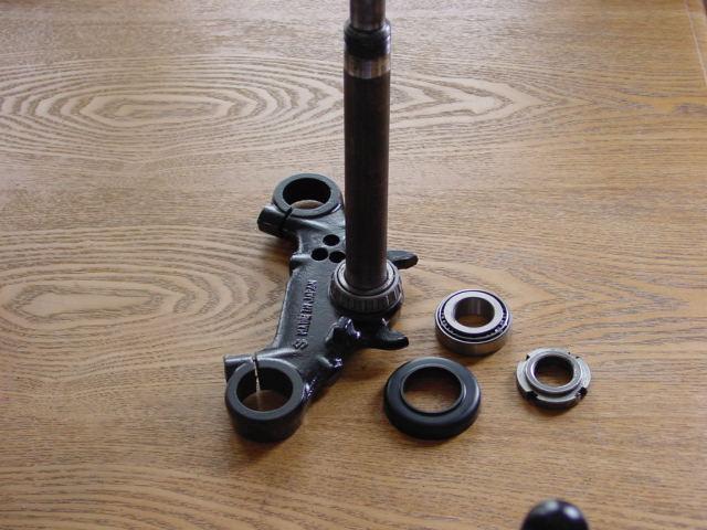 bearing. Holding the lower yoke in place fit the upper bearing, plastic dust cover and C ring adjuster nut screwing it as far down the stem as required to hold everything loosely in place.