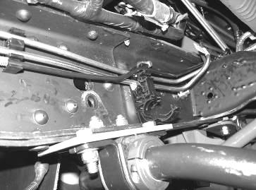 Once the hole is drilled, slide the bracket backwards on the fuel lines. Use care not to damage the lines. Re-install the factory nut and torque to 30 ft. lbs.