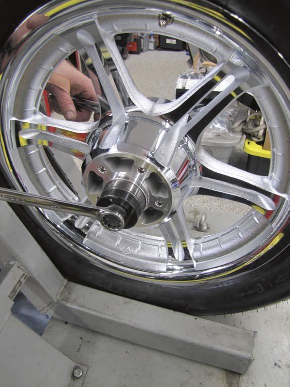 With the front wheel in a lift s wheel chock, 3 Dan uses a wheel bearing installation tool to