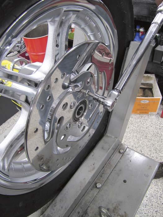 With blue Loctite on the new chrome H-D rotor 6 bolts, Dan installs the new polished H-D