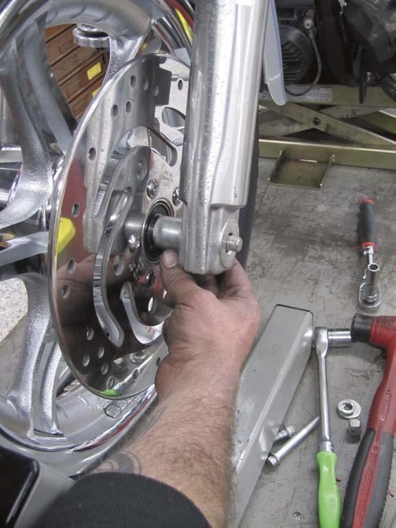 Dan then slips the stock front caliper around 13 the new rotor and secures it to the left lower leg using the stock bolts, blue Loctite, and a 12-point 10mm socket.