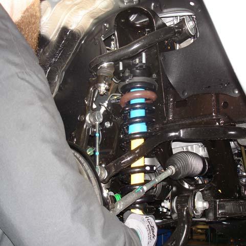 Install the strut assembly into the strut tower and secure using the upper (3) 10mm flange nuts.