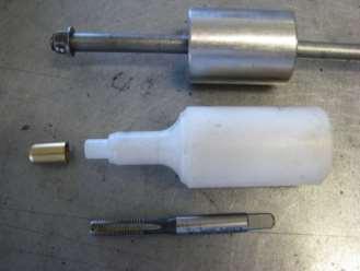 The tap (at bottom) is used to cut a thread into the needle seat (small part, middle-left).