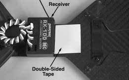 Install a large piece of double-sided tape onto the chassis directly behind the steering servo. Install the receiver onto the double-sided tape.