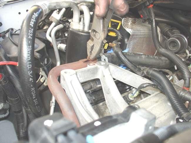 Step 15: Remove the bolt that is used to stiffen the heater tube to the manifold (located below alternator).