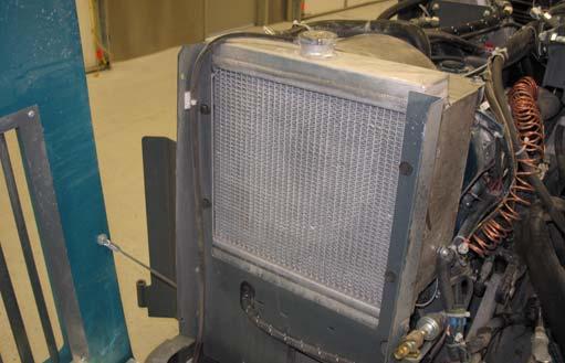 Check the radiator core exterior and hydraulic cooler fins for debris daily.