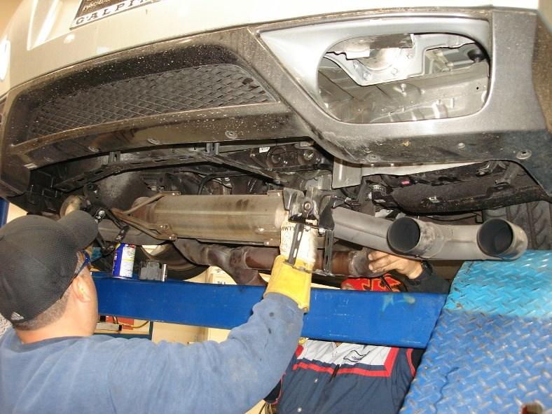 Using a muffler stand or an additional person to support the front muffler into position, remove the hangers from the rubber isolators.