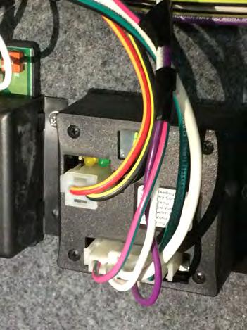 Hook up the short black wire with ring terminal to the terminal position with ground wires. Locate the pink wire with a green stripe (ignition wire) connecting to the slideout modules nearby.