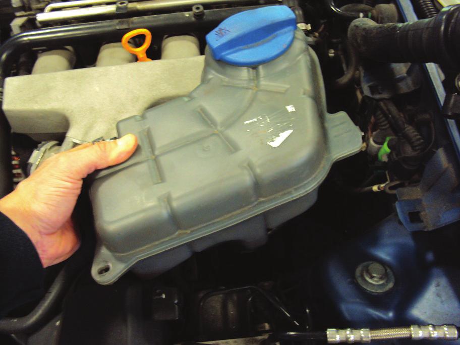 7. Unfasten the coolant reservoir and move away from plenum cover to reveal the upper bracket