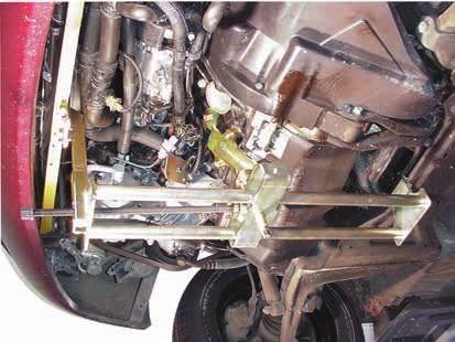 After undoing all mounting bolts and connections as well as loosening the exhaust flange, lift and pull/push the engine forwards to the right front side until the pulley of the crankshaft almost