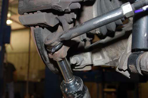 Using a 15mm wrench as shown remove the upper strut nuts. See Photo 1. Retain the factory hardware. 4.