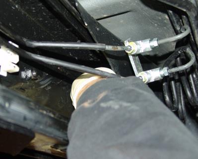 Remove 8mm bolt that holds brake lines to inside frame rail. Do not discard bolt.